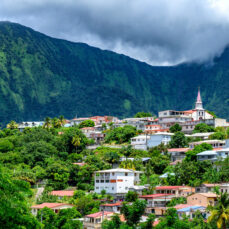 Vue d’un bourg antillais coloré niché au pied d’une montagne verdoyante