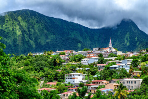 Vue d’un bourg antillais coloré niché au pied d’une montagne verdoyante